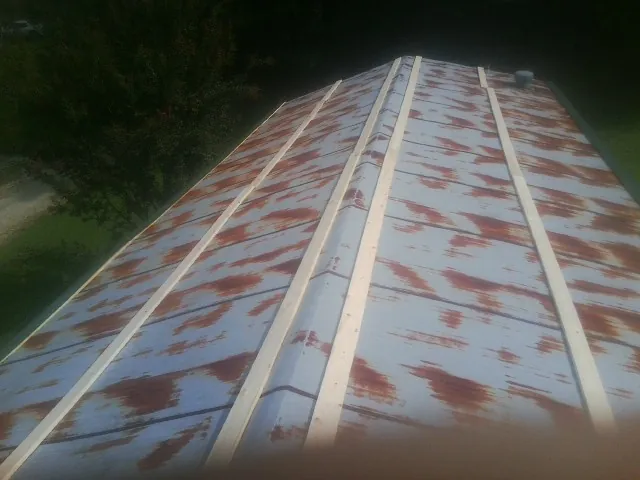 Rusted metal roof panels with new wood purlins before replacement — Storm Damage Roof Repair in Meeker by Roofing Brothers