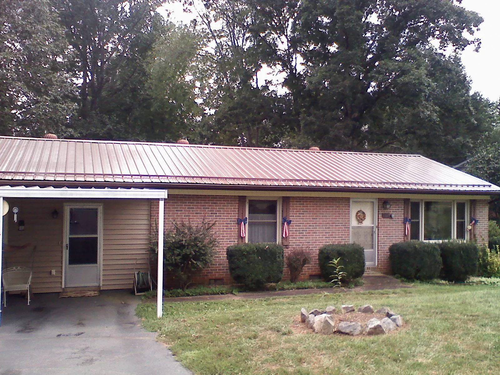 Bronze metal roof and carport on a brick ranch home — Roof Repair work by our crew in Meeker